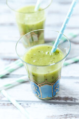Green smoothie topped with chia seeds on bright wooden background. Close up.	