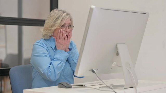 Old Businesswoman Reacting to Loss on Desktop Computer