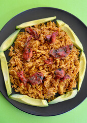Spicy Mexican style rice with sliced avocado and sun dried tomatoes in a plate.