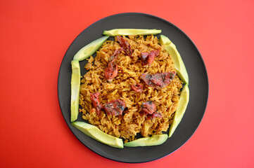Spicy Mexican style rice with sliced avocado and sun dried tomatoes in a plate.