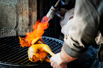 the human who burning the chicken on the grill with dramatic tone