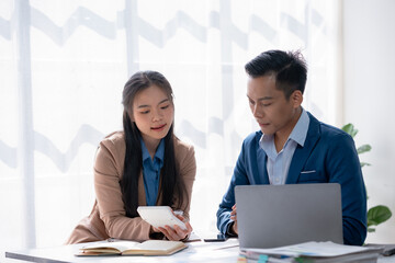 Business colleagues discuss and evaluate financial data together, reviewing charts on a document.