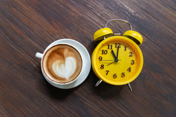 Coffee in a cup with an alarm clock. Awakening concept a boost of energy for the whole day.