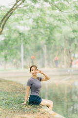 Asian woman stretching and warming up before going for a run at the park. Yoga, health care, weight loss exercise.