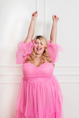 Happy curvy lady wearing pink elegant dress