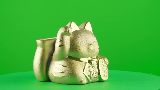 Gold golden maneki neko coin box piggy bank lucky japanese cat on green background chroma key background replacement backdrop objet in a turntable 3d spinning loop