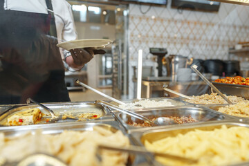 Chef Serving Freshly Cooked Dishes at a Restaurant Buffet During Lunchtime