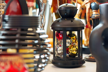 Black Lantern With Colorful Christmas Baubles in a Festive Display at an Indoor Market