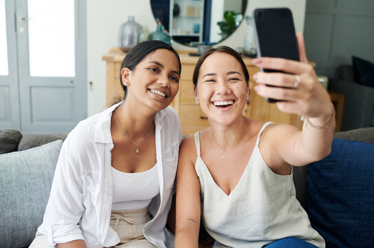 Happy woman, friends and photography with selfie on sofa for memory, bonding or moment together at home. Female person or young people with smile for picture or capture on mobile smartphone at house