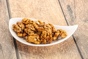 Cracked unshelled walnut in the bowl