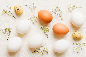 Happy Easter composition. Easter eggs on colored table with gypsophila. Natural dyed colorful eggs...