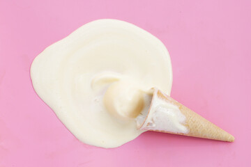 Melting ice cream balls with waffle cone on pink background.
