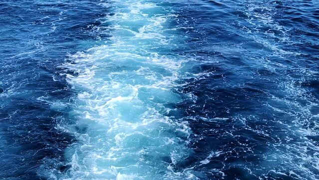 Waters as seen from a motorboat leaving background blue ocean motion foam closeup