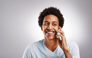 Phone call, smile and happy man in studio with mockup for gossip, news or web communication on grey background. Smartphone, listen and African model with networking, chat or streaming app connection