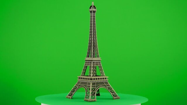 metal model figure of eiffel tower paris on green background chroma key background replacement backdrop objet in a turntable 3d spinning loop