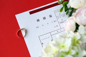 Japanese marriage registration blank document and wedding proposition ring and flowers on table close up