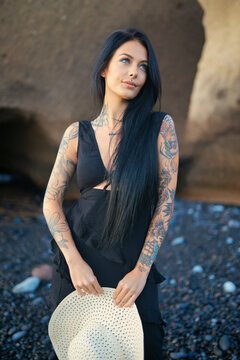 brunette girl on the beach with tattoos