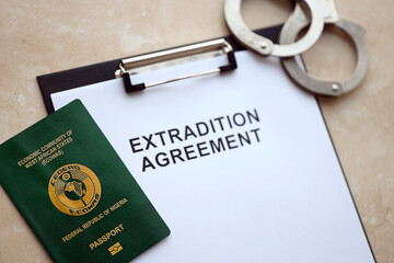 Passport of Pakistan and Extradition Agreement with handcuffs on table close up