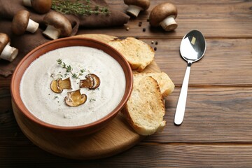 Fresh homemade mushroom soup served on wooden table. Space for text