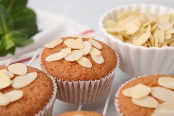 Muffins with fresh almond flakes on table, closeup