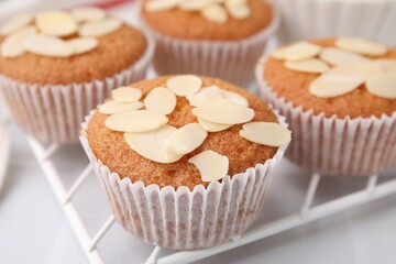 Muffins with fresh almond flakes on white table, closeup