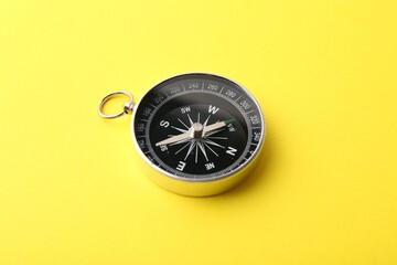 One compass on yellow background. Tourist equipment