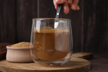 Dietary fiber. Woman stirring psyllium husk powder in water at table, closeup