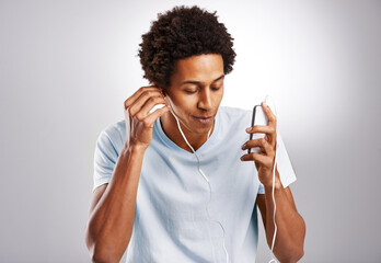 Black man, listening to music and cellphone with sound, radio and live streaming on a white studio background. African person, guy and model with smartphone and connection with digital app and audio