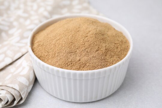 Dietary fiber. Psyllium husk powder in bowl on light grey table, closeup
