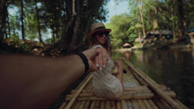Female tourist floats on bamboo raft. Woman tourist enjoying the bamboo rafting on the river with man beautiful nature landscape on smartphone. Vacation, cheerful tourism, travel, follow me concept.