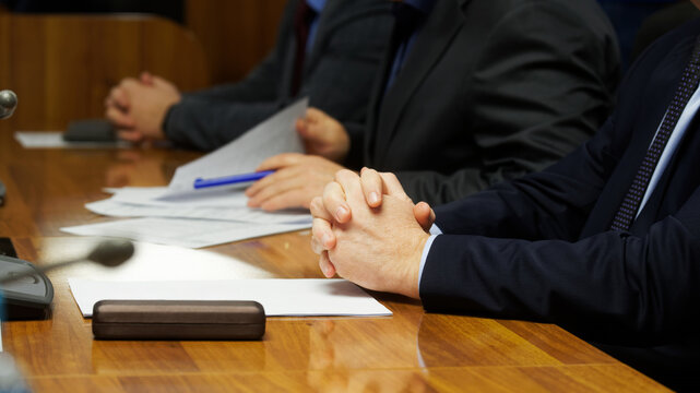 Male business team of three during a business meeting or negotiation. Professional work with documents. Photo. No face. Selective focus