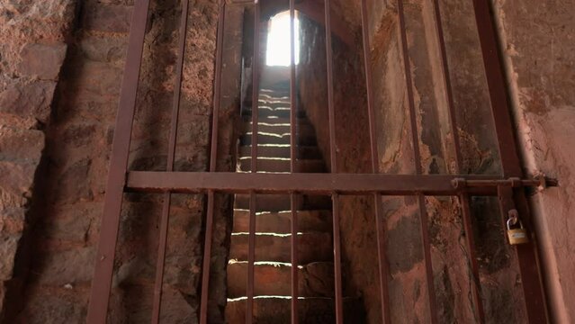 Locked iron gate with light streaming through at Dadi Poti Tombs, Hauz Khas, New Dehli