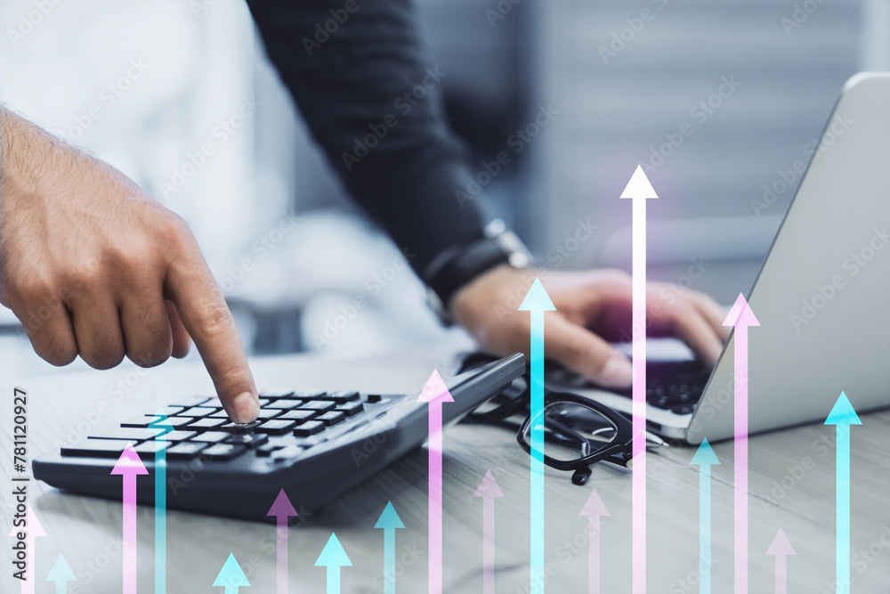 Poster close up of male hands using laptop and calculator at desk with various growing arrows on blurry bac