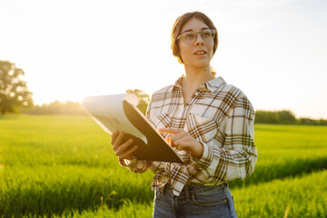 Woman agronomist checks the growth of the crop. Agriculture farm.