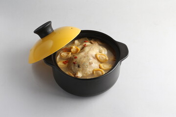 freshly hot stewed whole kampong chicken with abalone seafood in clay pot herbal soup on white table hotel chinese new year banquet restaurant halal food cafe menu