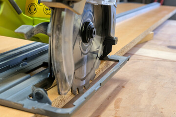 Circular saw on a DIY circular saw track, made of a long melamine wood piece and an aluminum rule.