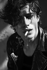 black and white photo of an attractive young man wearing a leather jacket, with wet hair smoking a cigarette grinning at the camera,  shadow play, bad boy,fictional character, book cover