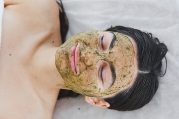 A beautician makes a mask on a woman's face. Mask-peeling for the face, spa procedures, skin care....