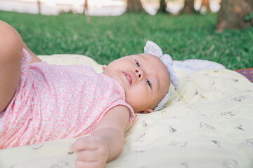 Infant Baby Girl is laying on her back in a pink bodysuit.