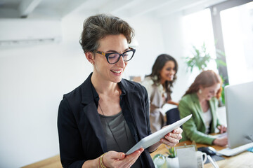 Business, mature woman and tablet in office with reading for creative research, schedule check or...
