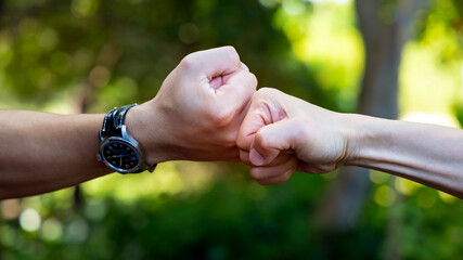 Deal of teamwork with the Man hand a fist bump commit as get together in the office.