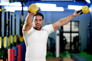 Portrait, man and weightlifting with kettlebell at gym for workout, exercise or strength training....