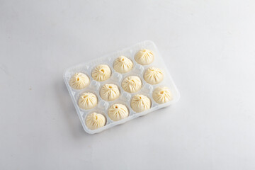 steamed Xiao long bao Shanghai small meat dumpling soup in frozen bento box pack on white background dim sum halal food breakfast menu for Hong Kong cafe super market