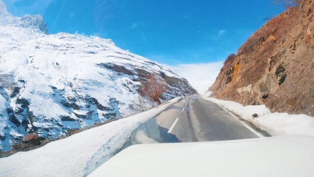 4K hyperlapse of car driving on snowy road during winter season in Lahaul, Himachal Pradesh, India. POV shot of mountain road during Holiday trip. Road trip concept.