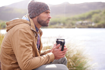 Camping, thinking and man with coffee by lake in nature for memory, reflection or outdoor adventure. Travel, morning and male person with hot beverage for relax, idea or winter morning in countryside