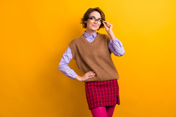 Photo of adorable smart girl dressed knitwear waistcoat touch glasses look at discount empty space isolated on yellow color background - obrazy, fototapety, plakaty