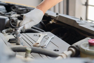 Hands of car mechanic in auto repair service. Auto mechanic working in garage.