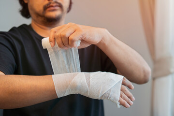 Middle aged man injured his hand using bandage to relieve the initial symptoms.