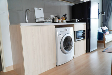 Laundry room interior with modern washing machine and household appliances.