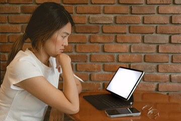 Side view of asian Thai woman using laptop, showing white blank screen, thinking for idea, working as freelance in cafe alone.